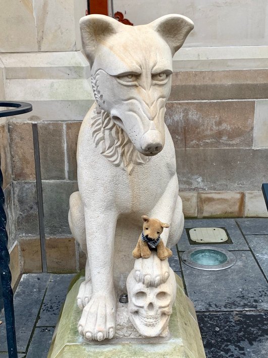 The fearless K9 memorial mascot atop a paw of one of the wolves by the entrance to Inverness Town Hall and (Credit: National K9 Memorial Trust)